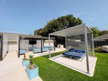 Outdoor living area with artificial turf and pergolas with unique sunshade 