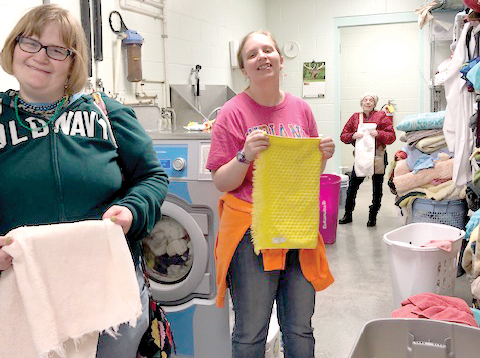 Neisha, Sam and Brighid fold laundry at the Bartholomew County Humane Society.