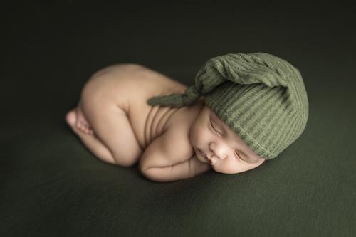 Newborn Boy posed on green.