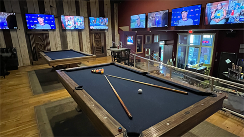 Upstairs in our restaurant's stadium seating, we have two pool tables and several televisions