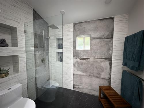Modern contrast: sleek black flooring meets raw, concrete-style walls.