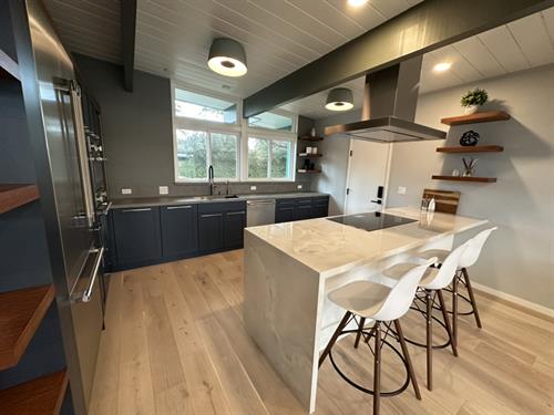 This kitchen remodel features a fresh mix of blue and white cabinets, paired with durable Dekton counters and backsplash.