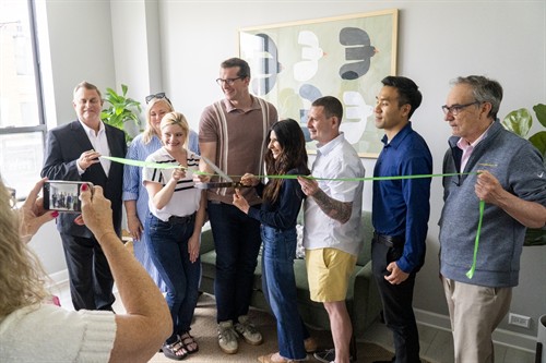 Community guests and LPTG team members take photos for a ribbon cutting at the Lakeview therapy office in Chicago.