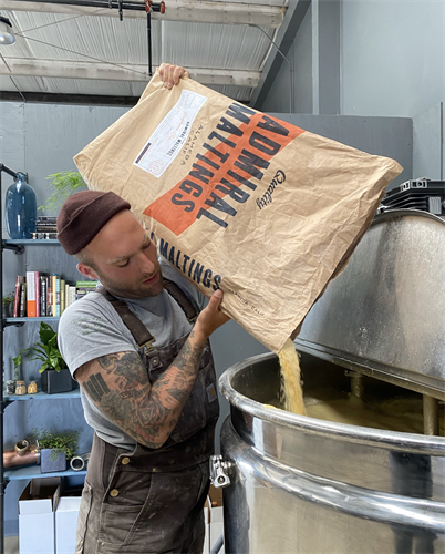 Anthony filling one of his mash cookers with admiral grains corn.. 