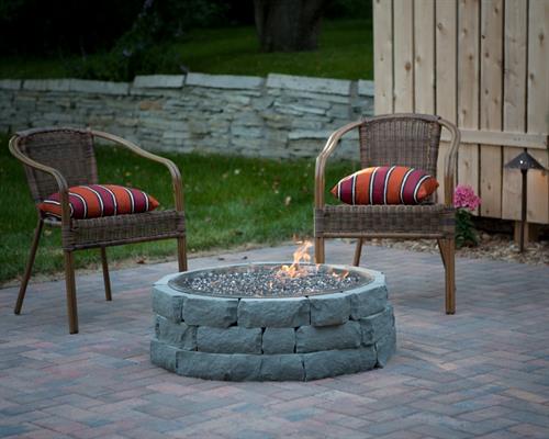 A paver patio, fire pit, and landscape project completed by Barrett Lawn Care