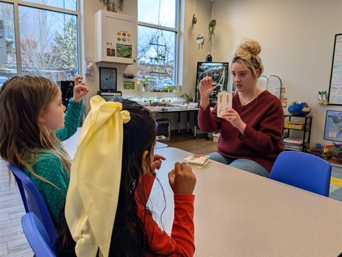 Teacher guiding students through ASL practice at Quantum STEM School.