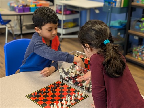 Students building strategy and critical thinking skills through chess and collaborative learning.