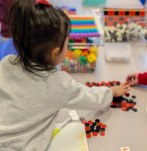 A student exploring early math concepts with hands-on learning materials at Quantum STEM School.