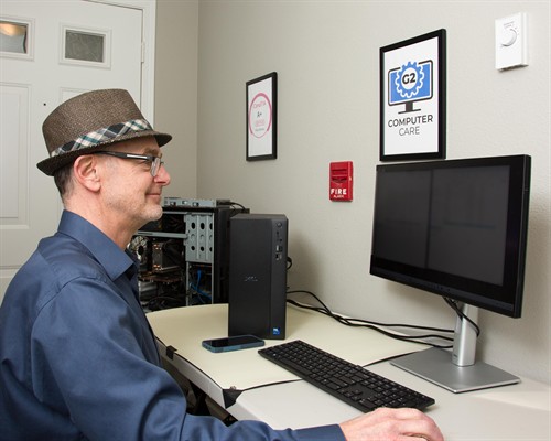 Computer technician repairing a desktop computer at a workbench