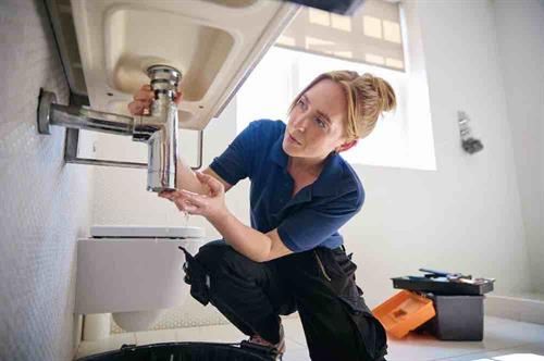 Gallery Image female-plumber-fixing-leak-in-domestic-bathroom-si-2024-10-21-00-56-27-utc.jpg