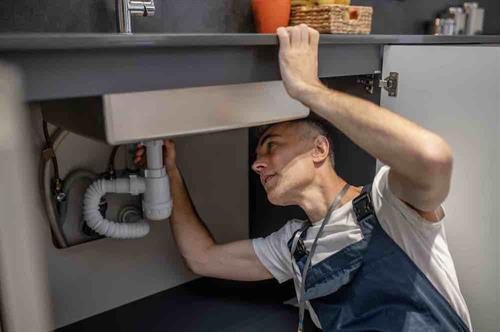 Gallery Image man-carefully-examining-bottom-of-sink-and-pipe-2024-10-18-04-54-31-utc.jpg