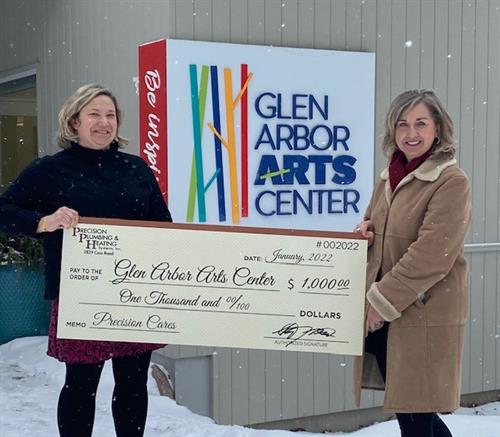 Glen Arbor Arts Center accepts a $1,000 check in January 2022 to help fun arts education in their community.