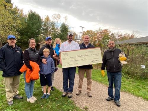Skegemog Raptor Center accepts their $1,000 check from Precision Cares so they can further their mission to rehabilitate raptors in Northern Michigan.