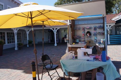 Sewing under the umbrellas at the Makerspace by the Sea at Shoreline Village