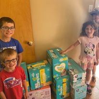 Family donating diapers for families at Fostering Hope Berks