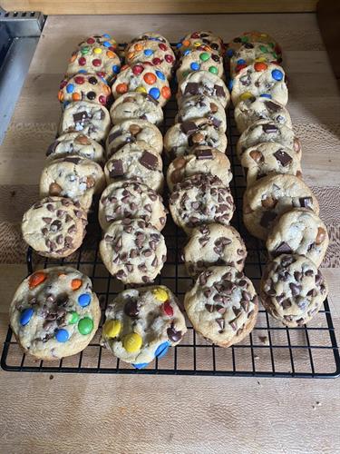 An array of cookie flavors: M&M, Caramel Chocolate Chunk, Chocolate Chips, and M&M Chocolate Chunk