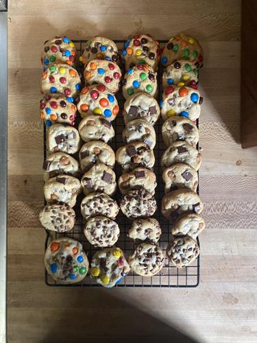 An array of cookie flavors: M&M, Caramel Chocolate Chunk, Chocolate Chips, and M&M Chocolate Chunk