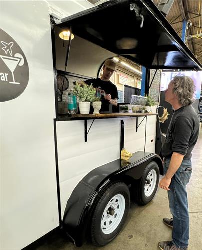 Event bartenders smile in mobile bar trailer at wedding show in Wilmington Massachusetts