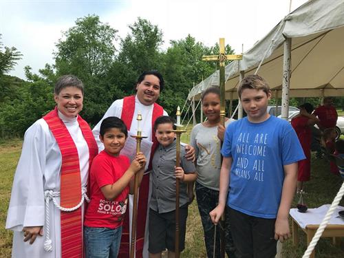Mtr. Sara and Padre Guillermo prepare for the Pentecost service with acolytes at our outdoor bilingual service in 2017.