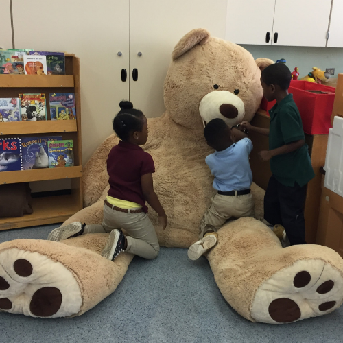 Young children at local school in counseling room with bear.