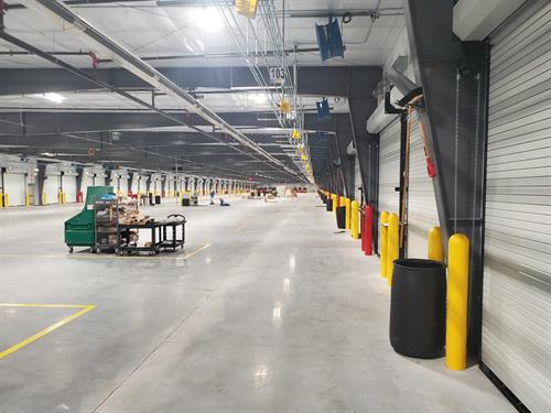 Completed industrial warehouse interior with loading docks polished concrete and conveyor systems built by commercial general contractor