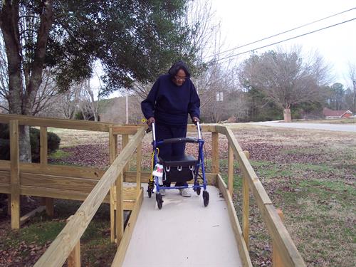 Client taking first steps on wheel chair ramp.