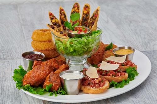 Jumbo Combo: signature wings, onion rings, Tupelo chicken tenders, Southwest spring rolls and tomato bruschetta. Served with honey mustard, blue cheese dressing and our house-made barbecue sauce. 