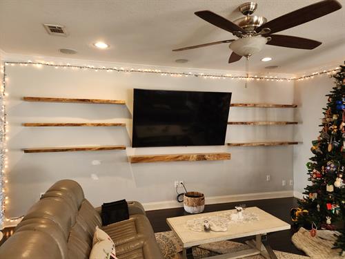 This custom project features a live-edge mantel and matching floating shelves, expertly crafted and installed to create a seamless, natural look for the customer’s living space.