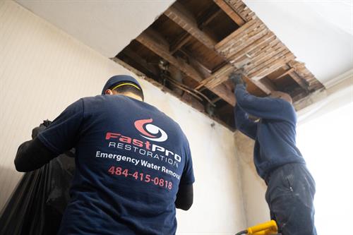 Our team removing a section of the client's ceiling that's been impacted from water damage. 