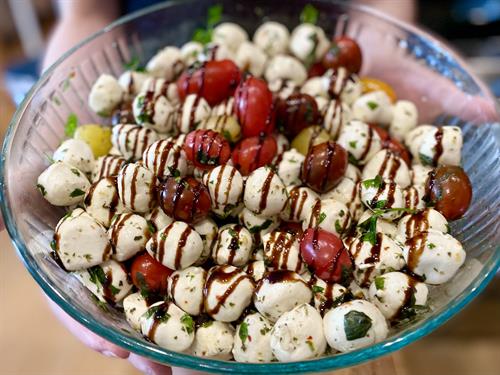 Caprese Skewers with Marinated Mozzarella Balls, Multicolor Tomatoes, Fresh Basil Drizzled with Balsamic Reduction