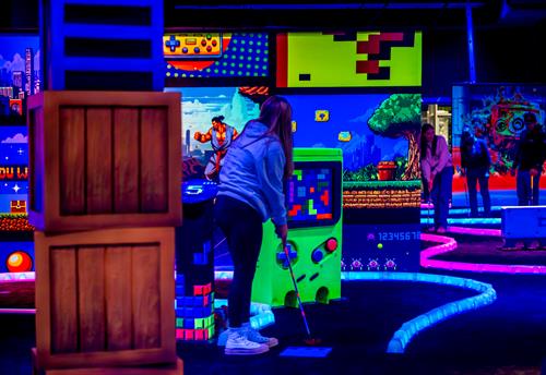Our glowing 18 hole mini-golf course features an 1980s classic arcade theme. Our glowing 18 hole mini-golf course features an 1980s classic arcade theme.
