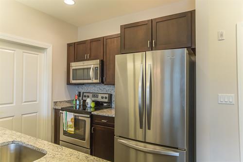 Kitchens feature granite countertops, stainless steel appliances, and Kohler fixtures