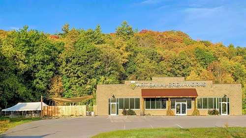 Fall at Artisanal Brew Works in Saratoga Springs, with Nature’s Edge Terrace surrounded by colorful foliage at the edge of the forest.