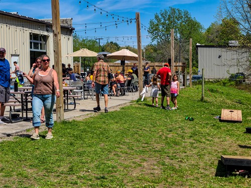 Outdoor dining at Artisanal Brew Works in Saratoga Springs featuring live music, a family-friendly atmosphere, and a spacious terrace just minutes from downtown.
