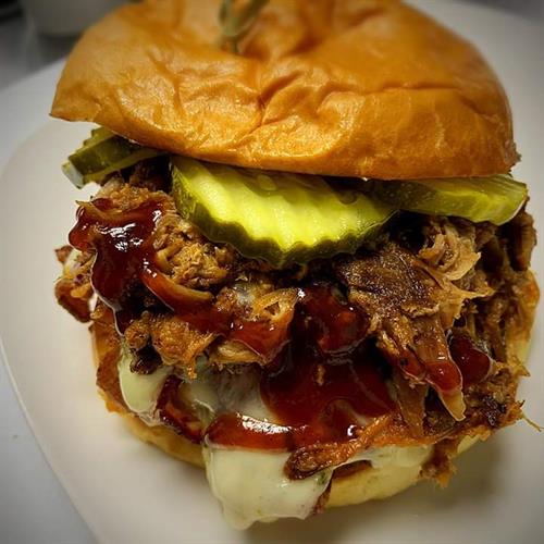 One of our signature dishes, The Par 3. Pork patty, wrapped in bacon, topped with pulled pork, pepper jack cheese and pickles. Must see it to believe it