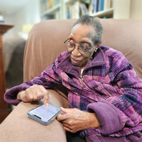 A senior client learning to use her phone as assistive technology.