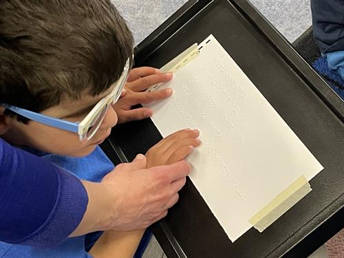 A youth client learning braille.