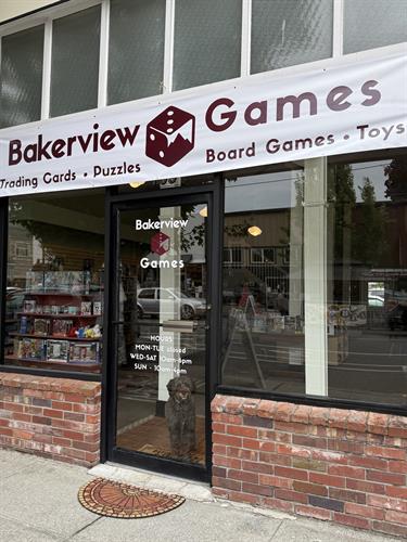 Store front with posted hours, and shop dog.