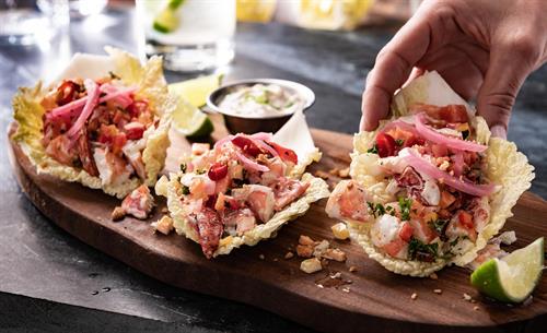 Lobster & Shrimp Tacos: Napa cabbage wrap, citrus aioli, shredded slaw, pickled red onion, dedo de moça peppers. 