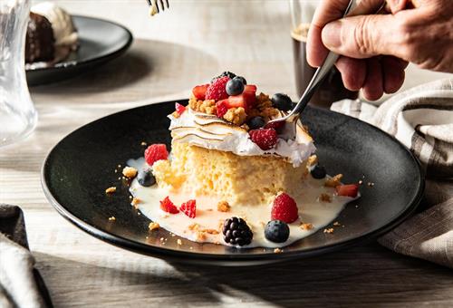 Tres Leches Cake: Vanilla sponge cake soaked in three types of milk, topped with toasted meringue and mixed berries.