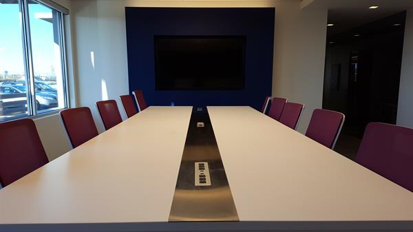 The work table in our hoteling space features charging stations and connections for presenters to extend their device display onto the wall-mounted TV.