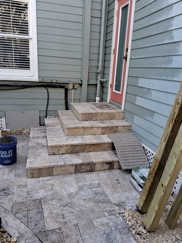 Open tile steps with no railing, creating a safety concern at the back entrance.