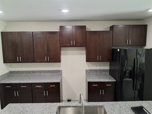 Kitchen fully repaired with restored cabinetry, countertops, lighting, and a clean finished look.