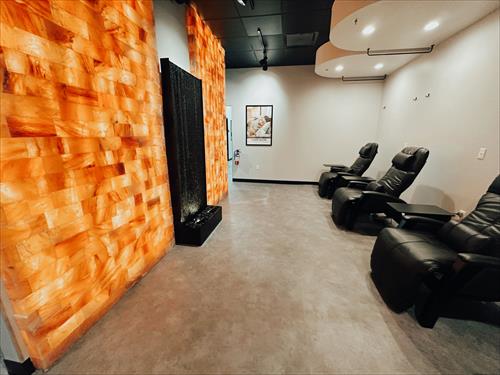 Open room IV infusion area with a salt wall and waterfall and zero gravity heated leather chairs