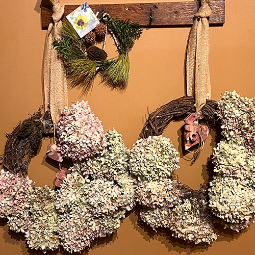 Locally sourced dried hydrangea wreath with magnolia and pine mini wreath, complete with cedar carved accents
