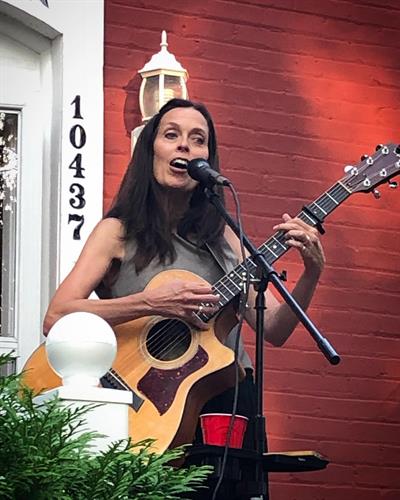Jen Thomas singing on the front porch of the Cottage Gallery