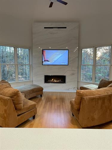 Marble wall with linear fireplace and TV shadow box