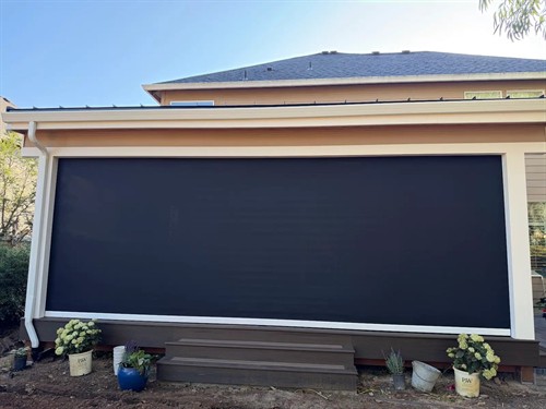 A recessed motorized screen lowers across the patio opening and retracts into a custom soffit when not in use.