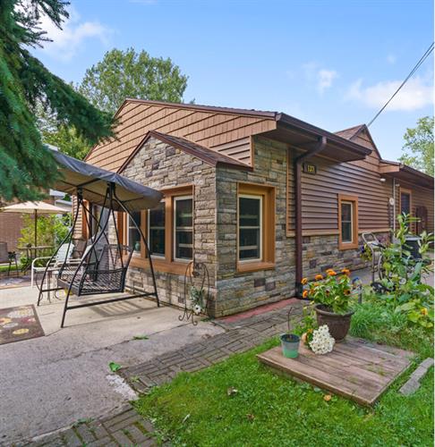 Experience the incredible transformation of this Brighton, MI home with a custom siding remodel. Now featuring beautiful Versetta Stone (Ledgestone/Tight-Cut) accent walls, Certainteed Monogram Cedar Shake gable siding, and Monogram vinyl siding. Stunning curb appeal!