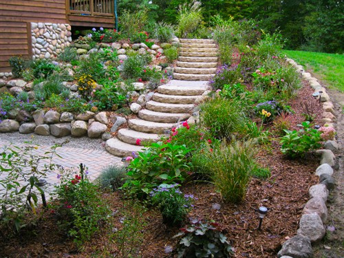 Softscape planting bed with ledge rock steps, natural boulder retaining wall and paver patio